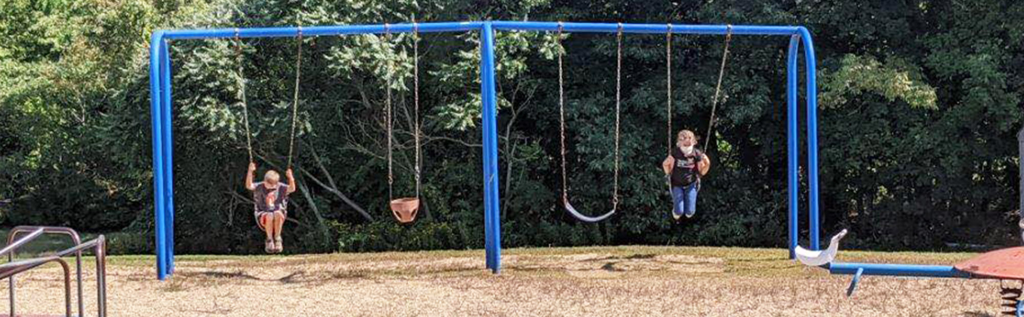 Students enjoying the swings on the school playground